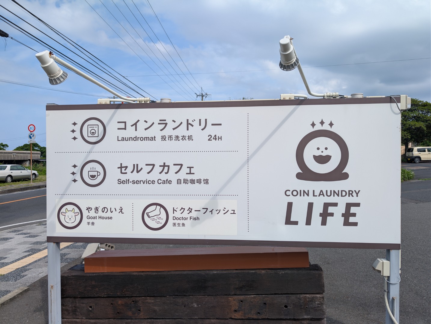 Roadside sign for COIN Laundry Life in Yakushima