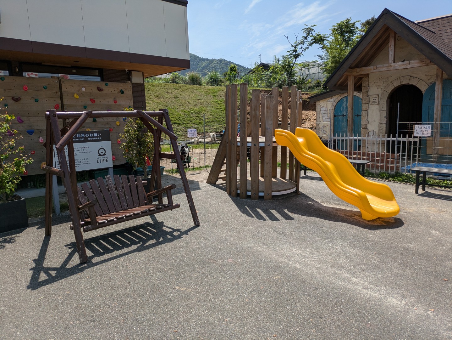 A playground, bench and goat farm at a Yakushima coin laundry.